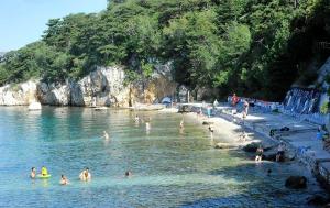 a group of people in the water at a beach at Apartman Antonia in Podhum