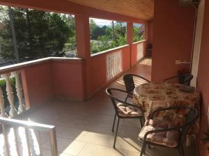 a patio with a table and chairs on a balcony at Apartman Antonia in Podhum