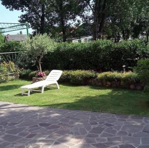 a white bench sitting on the grass in a yard at Apartman Antonia in Podhum +1 photo