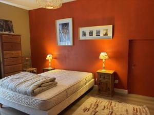 une chambre avec des murs orange et un lit et deux lampes dans l'établissement Appartement fonctionnel avec balcons, parking et Wi-Fi - Centre de Villard de Lans - FR-1-548-19, à Villard-de-Lans