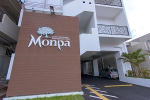 a sign for a momeda building in a parking lot at Condominium Hotel Monpa in Chatan