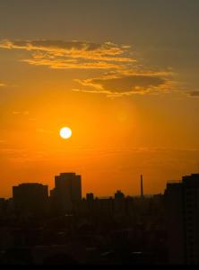 einen Sonnenuntergang über einer Stadt mit der Sonne am Himmel in der Unterkunft POA Heart Stay - Vista para o Guaíba no Centro Médico de Porto Alegre in Porto Alegre