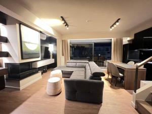 un salon avec un canapé et une télévision dans l'établissement Cleopatra City Center Luxury E2 Maisonette, à Vólos