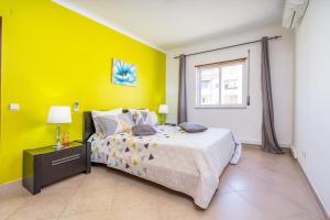 ein Schlafzimmer mit einem Bett und einer gelben Wand in der Unterkunft Two Bedroom Apartment - 110m2, AC, Terrace, Wi-Fi in Lagos