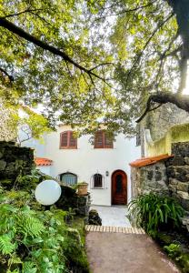 a white house with red windows and a door at Villa Talia Sweet Rooms B&B in Ischia