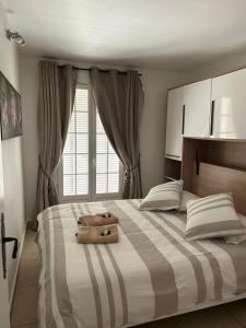 a bedroom with a large bed with a suitcase on it at L'Arche de Porquerolles in Porquerolles