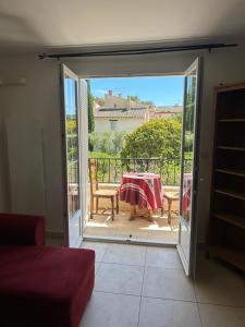 a sliding glass door leading to a patio with a table at L'Arche de Porquerolles in Porquerolles
