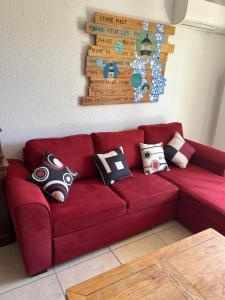 a red couch with pillows on it in a living room at L'Arche de Porquerolles in Porquerolles