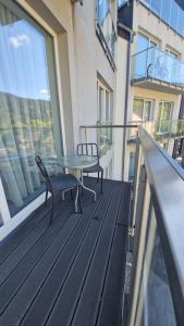 a balcony with a table and chairs on a building at Apartament Czarna Góra Silver in Sienna