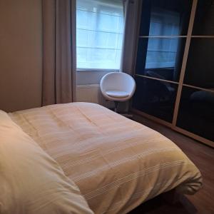 a bed in a room with a window and a chair at l'envie d'ailleurs in Malmedy +3 photos