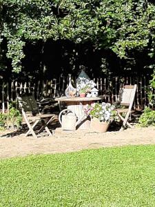 a picnic table with two chairs and flowers on it at l'envie d'ailleurs in Malmedy