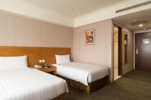 Postel nebo postele na pokoji v ubytování Fushin Hotel Taipei