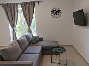 a living room with a couch and a window at Apartment & Room Aleksandra in Rab