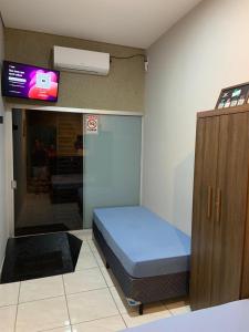 ein kleines Zimmer mit einem Bett und einem Fernseher in der Unterkunft Flat MDC 01 in Iturama