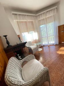 a living room with two wicker chairs and a fireplace at La casa by M&G vacation home in Soglio