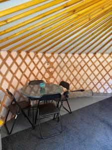 a table and chairs and a bed in a yurt at Sheviock Barton Yurt in Sheviock