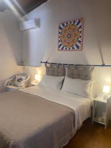 a bedroom with a bed with a picture on the wall at Villamare in Custonaci +20 photos