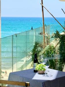 a table with a bottle of wine and glasses on the beach at Alonas Apartments 2BR view apartment in Haifa