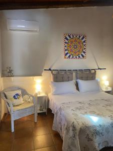 a bedroom with a large bed and a chair at Villamare in Custonaci