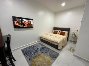 a bedroom with a bed and a tv on the wall at PEARL Suite Sungai Karang Balok in Kuantan