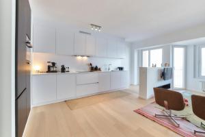 cocina con armarios blancos y suelo de madera en Parador Heaven, en Mellet 8 fotos más