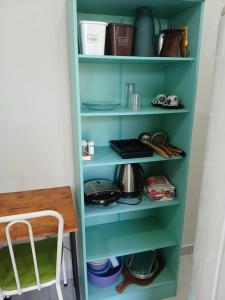 a green pantry with dishes and a table at Kitnet mobiliada aconchegante in Londrina