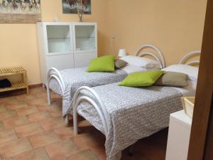two beds with green pillows in a bedroom at Akron B&B in SantʼAlessio Siculo