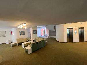 een woonkamer met banken en stoelen in een gebouw bij Euro Residence in Lignano Sabbiadoro +9 foto's