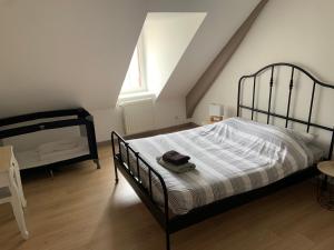 Un dormitorio con una cama negra y una ventana. en La Taverne Bretonne, en Renac