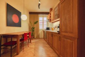 a kitchen with a wooden table and red chairs at NELIS I Boutique Apartments in Old Town in Prague +38 photos