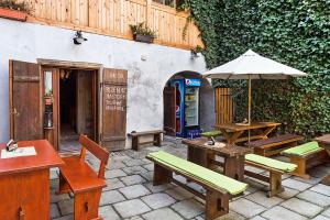 a patio with tables and benches and an umbrella at Travel Hostel in Český Krumlov
