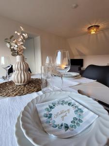a table with wine glasses and a plate on it at Ferienwohnung Wiese in Langelsheim