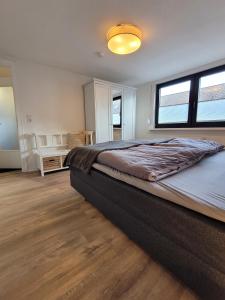 a bedroom with a large bed and two windows at Ferienwohnung Wiese in Langelsheim