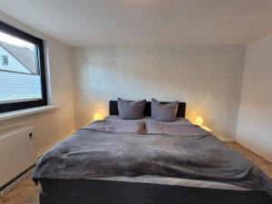 a bedroom with a large bed with two pillows at Ferienwohnung Wiese in Langelsheim