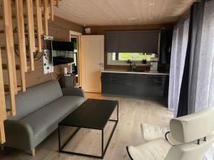 a living room with a couch and a table and a kitchen at Modern holiday home in Ålesund