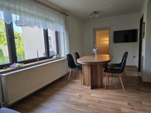 a dining room with a table and chairs and windows at Waitzdorfer Landhaus Pieper in Hohnstein