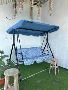 a blue canopy in a room with two stools at Villa Pondok Ima in Tlekung