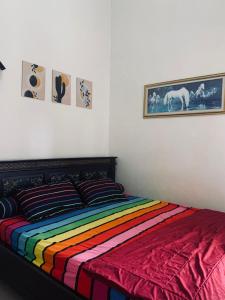 a bedroom with a bed with a colorful blanket at Villa Pondok Ima in Tlekung