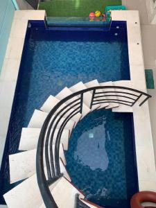 a swimming pool with a spiral staircase in the water at Villa Pondok Ima in Tlekung