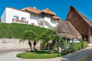 a white building with palm trees in front of it at Luxury and confort in Quadra Alea in Playa del Carmen
