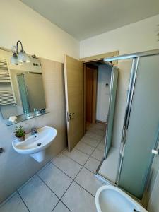 un bagno con lavandino e doccia di Residence Capinera a Sottomarina Altre 37 foto