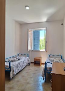 a bedroom with two beds and a window at Casa Celeste in Budoni