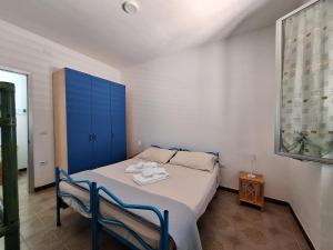 a bedroom with a bed and a blue cabinet at Casa Celeste in Budoni