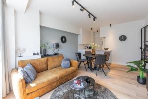 a living room with a couch and a table at Beau Soleil in Ostend