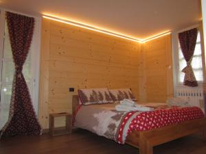 a bedroom with a bed and a wooden wall at Family House in Formazza