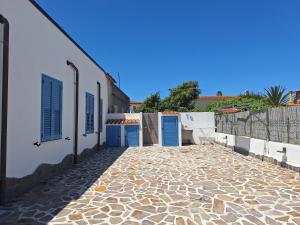 a stone walkway with blue doors on a building at Casa Celeste in Budoni