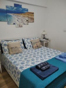 una camera da letto con un letto con un piumone blu di Poggio del Sole a Letoianni