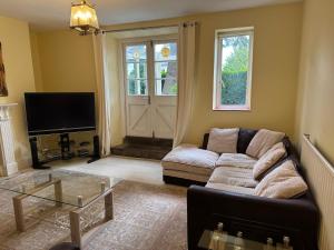 a living room with a couch and a tv at Garden View in Great Malvern