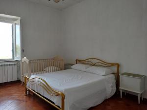 a bedroom with a bed with white sheets and a window at Sunny House in Parghelia