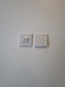 two light switches on a white wall at Kampala Studio with Lake Breeze in Kampala